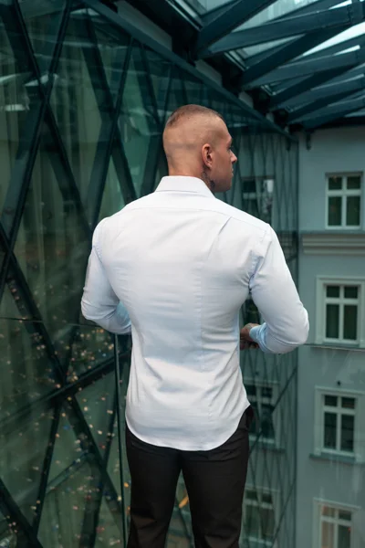 Mann mit breiten Schultern und muskulösem Rücken in einem hellblauen Muscle-Fit-Hemd – perfekte Passform für Bodybuilder