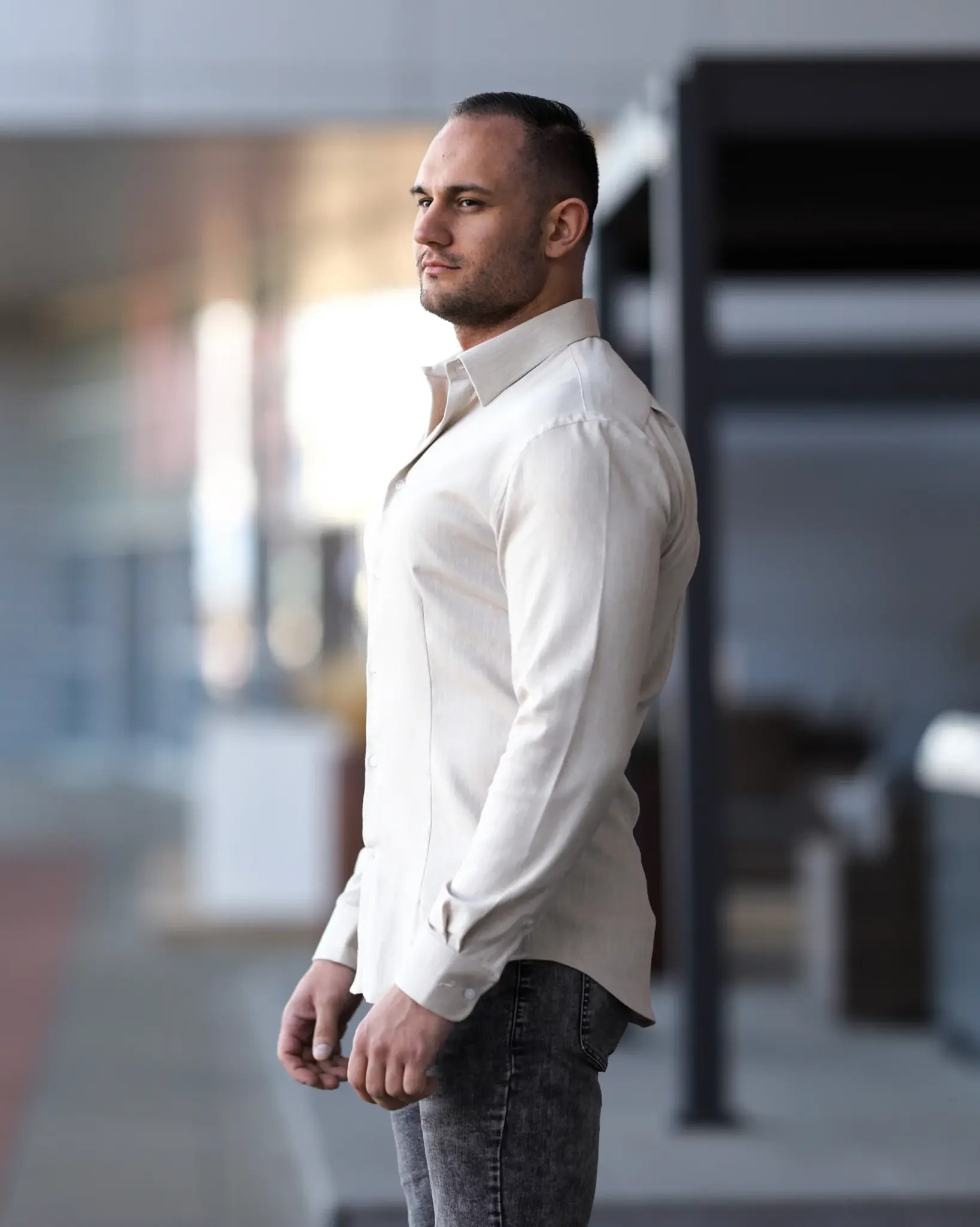 Athletischer Mann im weißen Muscle-Fit-Hemd von der Seite – perfekte Passform für Bodybuilder und Kraftsportler